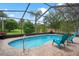 Enclosed pool with brick patio, outdoor furniture, and view of a lush yard, perfect for relaxation at 5140 Eclipse Ct, Spring Hill, FL 34607