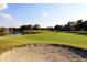 Scenic view of golf green and pond with a sand trap at 5210 Gato Del Sol Cir, Wesley Chapel, FL 33544