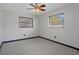 This bedroom has neutral carpet, two windows, a ceiling fan, and neutral paint at 650 Jacaranda St, Dunedin, FL 34698