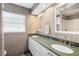 Bathroom featuring tiled walls, double sinks, framed mirrors, and natural light at 709 Flamingo Dr, Apollo Beach, FL 33572