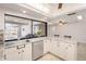 Well-lit kitchen featuring white cabinetry, stainless steel appliances, marble countertops, and views of the outdoor space at 709 Flamingo Dr, Apollo Beach, FL 33572