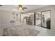 Open-concept living room with tile flooring, ceiling fan, and access to the kitchen and outdoor area at 709 Flamingo Dr, Apollo Beach, FL 33572