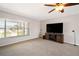 Bright living room with large window, ceiling fan and TV over a wood media center at 709 Flamingo Dr, Apollo Beach, FL 33572