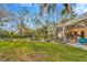 Expansive backyard with a manicured lawn, fountain, and covered patio for entertaining at 7201 Hodgewood Ct, Tampa, FL 33614
