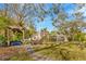 Expansive backyard featuring mature trees, a cozy pergola swing, fire pit, and home exterior at 7201 Hodgewood Ct, Tampa, FL 33614