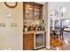Elegant home bar featuring glass shelving, wine storage, beverage cooler, and granite countertop, perfect for entertaining at 7201 Hodgewood Ct, Tampa, FL 33614
