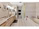 Bathroom featuring a tub, glass block shower, and double vanity with lots of storage at 7201 Hodgewood Ct, Tampa, FL 33614