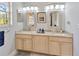 Well-lit bathroom with a double vanity, granite countertop, and decorative mirrors at 7201 Hodgewood Ct, Tampa, FL 33614