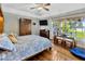 Bright bedroom with wood floors, large window overlooking the lake, and wooden furniture at 7201 Hodgewood Ct, Tampa, FL 33614