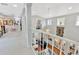 Bright foyer with carpeted floor and railing overlooking the living room, offering natural light and a sense of spaciousness at 7201 Hodgewood Ct, Tampa, FL 33614