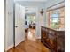 Hallway view showcasing hardwood floors, natural light, and an open doorway at 7201 Hodgewood Ct, Tampa, FL 33614