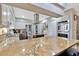 Open concept kitchen with stainless steel appliances, granite countertops, white cabinets, and large center island with cooktop at 7201 Hodgewood Ct, Tampa, FL 33614