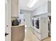 Functional laundry room with side-by-side washer and dryer, ample cabinet space, and convenient access to the backyard at 7201 Hodgewood Ct, Tampa, FL 33614