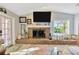 Living room featuring a brick fireplace with a white mantel and a large window with a lake view at 7201 Hodgewood Ct, Tampa, FL 33614