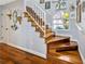 Elegant staircase with wooden steps, white railings, and a window providing natural light, complementing the hardwood floors at 7201 Hodgewood Ct, Tampa, FL 33614