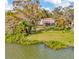 Stunning waterfront estate with lush landscaping, mature trees, and panoramic water views from the expansive lawn at 7201 Hodgewood Ct, Tampa, FL 33614