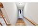 Wooden staircase leading down with white walls and baseboards, connecting the levels of the home at 9954 Indian Key Trl # 14, Seminole, FL 33776