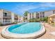 Community pool area with lounge chairs, palm trees, and multiple buildings at 9960 5Th St. N. # 304, St Petersburg, FL 33702