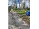 View of a dirt driveway leading to a wooded property with mature trees and a trash receptacle at 11616 Bullfrog Creek Rd, Gibsonton, FL 33534