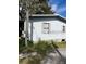 Exterior view of a single-story home featuring vinyl siding and small windows at 11616 Bullfrog Creek Rd, Gibsonton, FL 33534