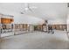 Open-concept living room with fireplace needing renovation, and ceiling fans, offering potential for customization at 120 Carlyle Cir, Palm Harbor, FL 34683
