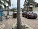 Beautiful home with a paved driveway and landscaping with a red SUV at 19109 Gulf Blvd, Indian Shores, FL 33785