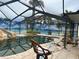 Enjoy this screened-in pool with a rock waterfall, slide, and beach themed privacy screen at 19109 Gulf Blvd, Indian Shores, FL 33785