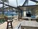 Outdoor pool area with a bar stool, chairs, and a dark screened patio area at 19109 Gulf Blvd, Indian Shores, FL 33785