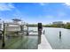 Boat and boat lift with a view of the water and other condos on a sunny day at 19651 Gulf Blvd # A6, Indian Shores, FL 33785