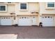 Exterior view of yellow townhomes with brick driveway and white garages at 19651 Gulf Blvd # A6, Indian Shores, FL 33785