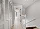 Hallway with wood-look floors and white trim, leading towards a sunlit room with balcony at 19651 Gulf Blvd # A6, Indian Shores, FL 33785