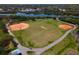 Aerial view of a baseball field with lush green surroundings and a beautiful pond at 2009 Sheffield Ct, Oldsmar, FL 34677