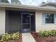 Charming home entrance with a screened-in porch, blue shutters, and a well-maintained yard at 2131 Ridge S Rd # 86, Largo, FL 33778