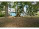 Expansive backyard shows tropical trees, blue house exterior, and screened-in pool at 22002 Darley Pl, Land O Lakes, FL 34639