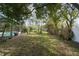 Large backyard with lush lawn, mature trees, fenced perimeter, and inviting pool area at 22002 Darley Pl, Land O Lakes, FL 34639