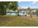 A backyard with an in-ground pool, screened-in lanai, lush green grass and mature trees at 22002 Darley Pl, Land O Lakes, FL 34639