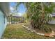 Lush backyard featuring tropical foliage, block-lined garden beds, and screened-in pool at 22002 Darley Pl, Land O Lakes, FL 34639
