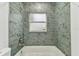 Bathroom featuring turquoise tile shower and tub with window at 22002 Darley Pl, Land O Lakes, FL 34639