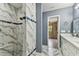 Bathroom featuring marble tiling and shower with built in bench and white cabinets at 22002 Darley Pl, Land O Lakes, FL 34639
