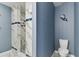 Bathroom featuring a remodeled shower with marble tiling and blue accents at 22002 Darley Pl, Land O Lakes, FL 34639