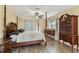 This bedroom features natural light, a ceiling fan, and hardwood flooring at 22002 Darley Pl, Land O Lakes, FL 34639