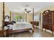 This bedroom features natural light, a ceiling fan, and hardwood flooring at 22002 Darley Pl, Land O Lakes, FL 34639