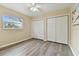 Bedroom features wood-look floors, neutral walls, a ceiling fan and windows overlooking the yard at 22002 Darley Pl, Land O Lakes, FL 34639