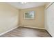 Bedroom with wood-look floors, tan walls, a ceiling fan and window overlooking the yard at 22002 Darley Pl, Land O Lakes, FL 34639