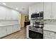 Updated kitchen features modern white cabinets, stainless steel appliances, and quartz countertops at 22002 Darley Pl, Land O Lakes, FL 34639