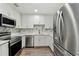 Stylish kitchen showcasing stainless steel appliances, white cabinets, quartz countertops, and a marble backsplash at 22002 Darley Pl, Land O Lakes, FL 34639