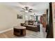 Cozy living room with a brown leather sofa, hardwood-style floors, and natural lighting at 22002 Darley Pl, Land O Lakes, FL 34639