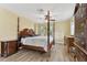 Bedroom featuring a four-poster bed, wood floors, and natural light at 22002 Darley Pl, Land O Lakes, FL 34639