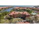 An aerial view of waterfront condos with boat docks and a pool overlooking a lake and ocean at 2709 Via Cipriani # 532B, Clearwater, FL 33764