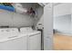 Bright laundry room equipped with a washer, dryer, and shelving at 2709 Via Cipriani # 532B, Clearwater, FL 33764
